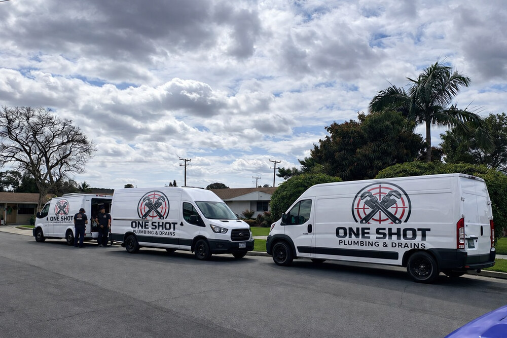Three One Shot Plumbing and Drains service vans with uniformed technicians
