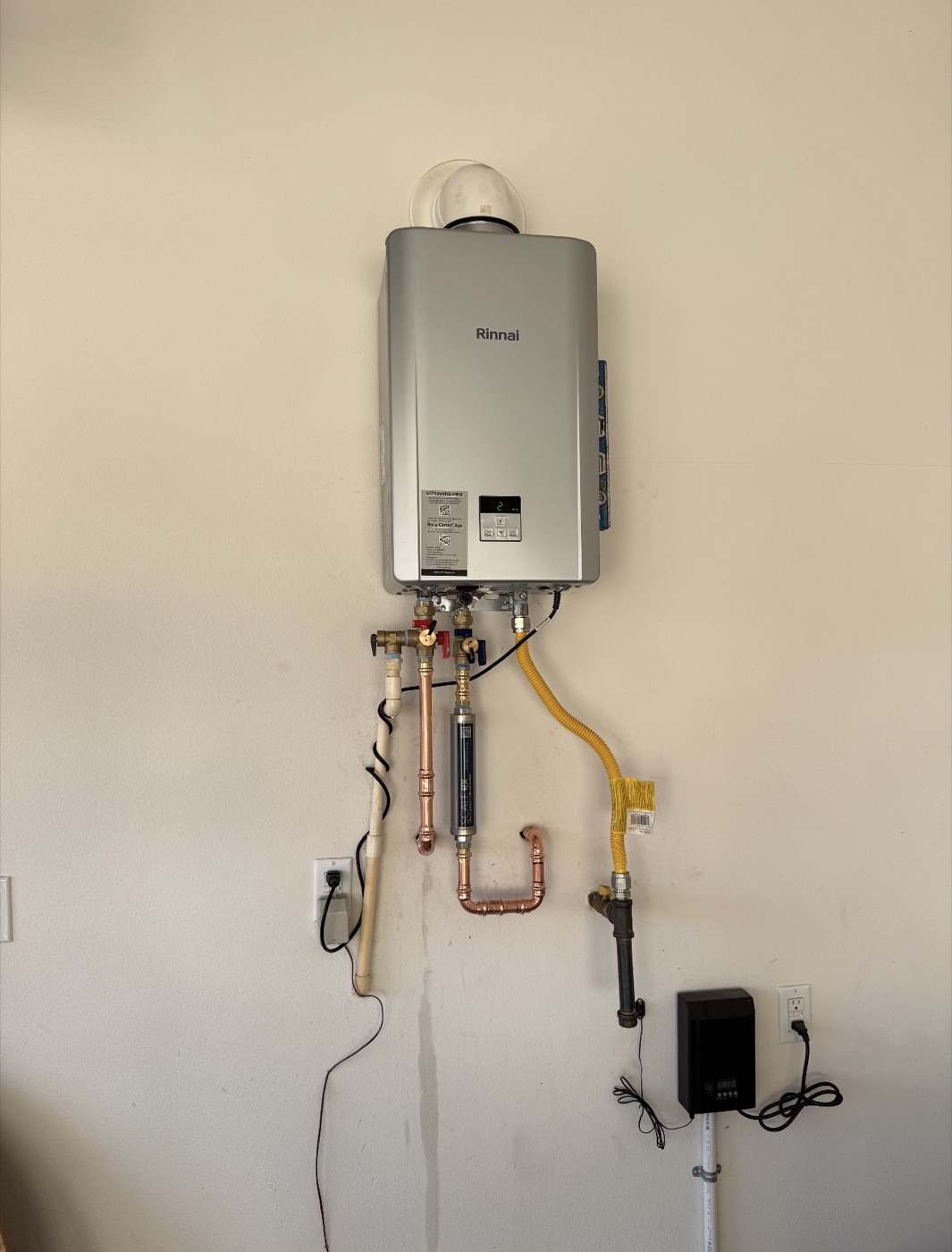 Wall-mounted tankless water heater with visible service connections