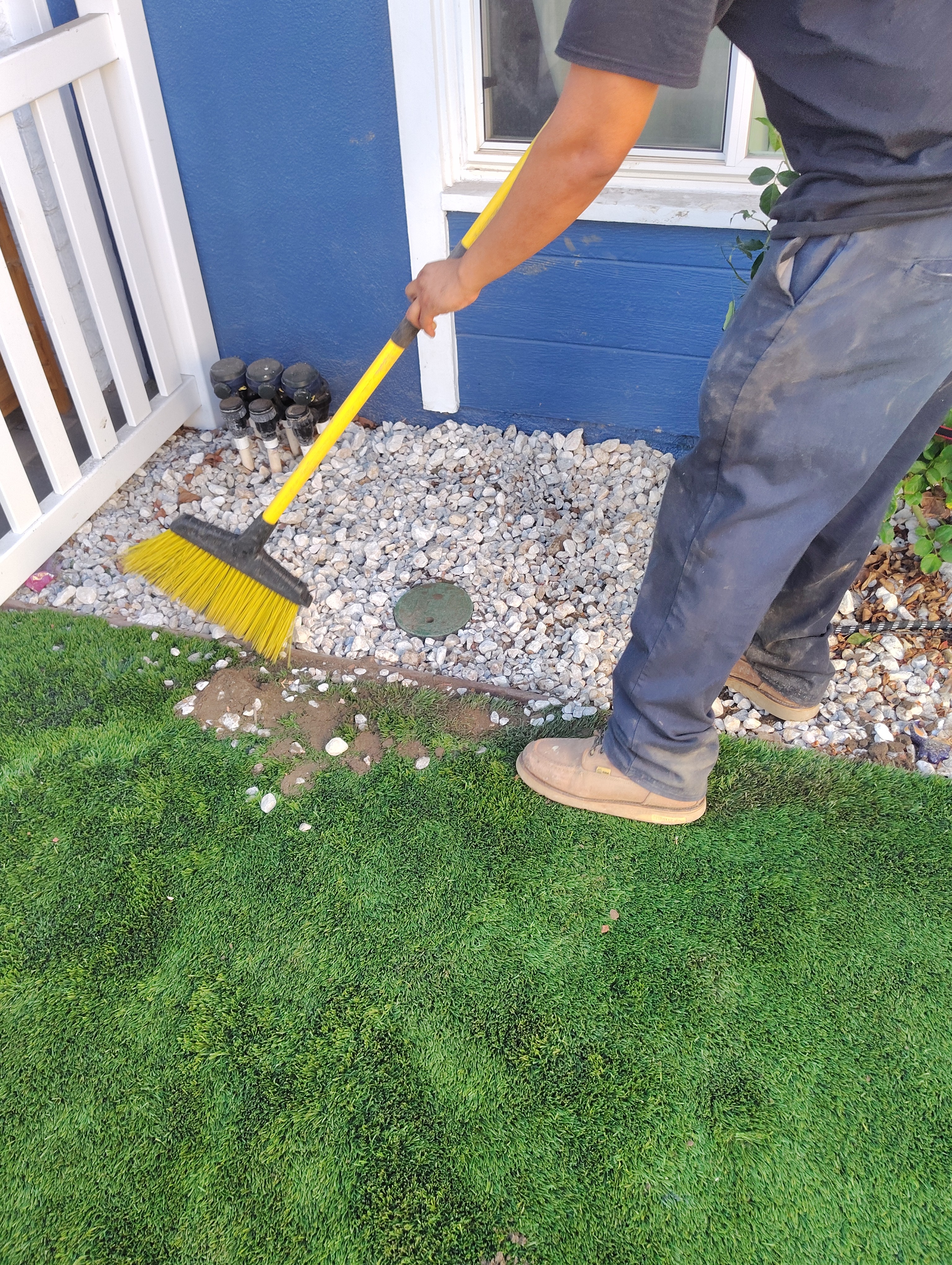 Technician sweeping around the exterior plumbing access point