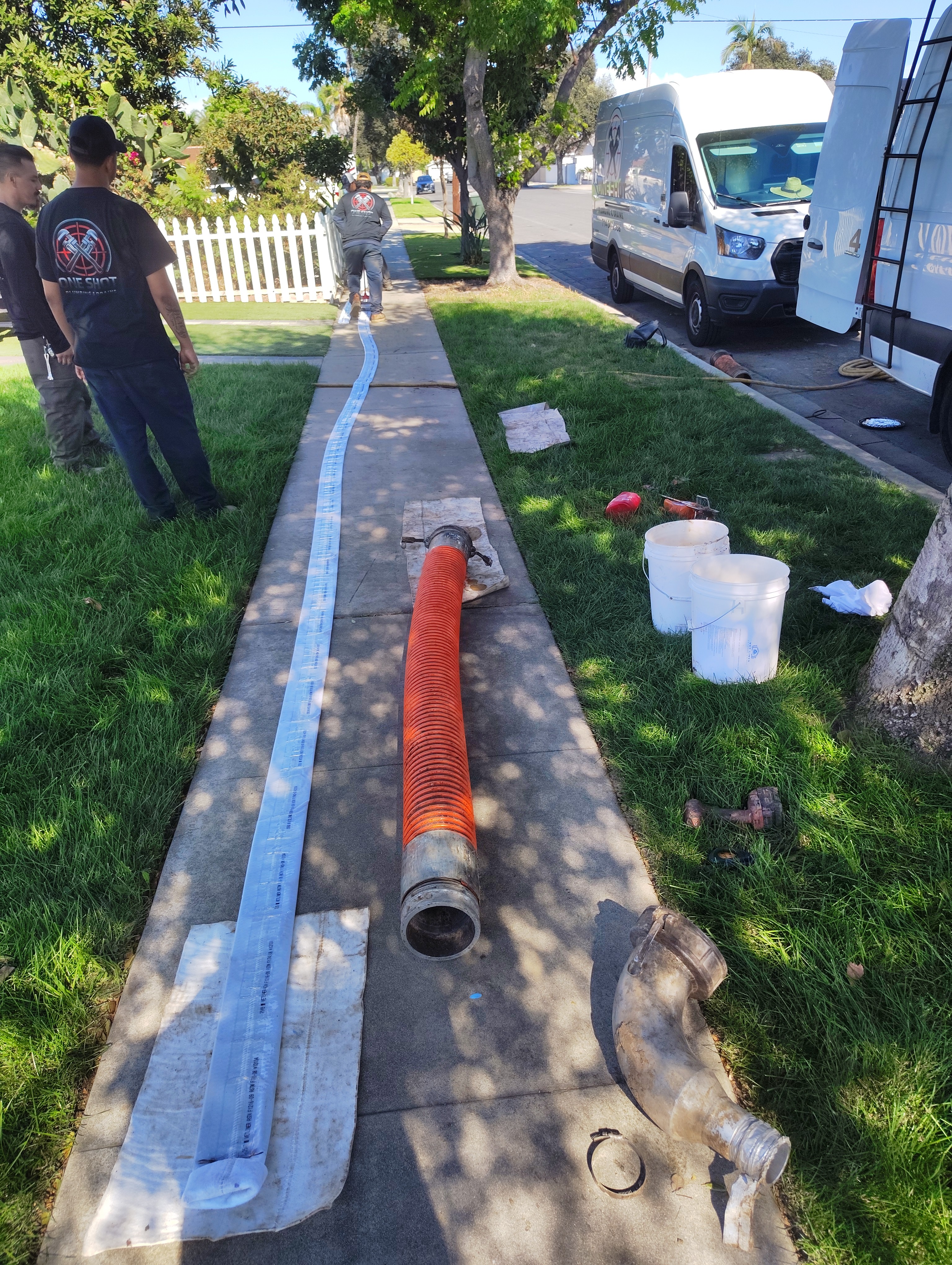 One Shot crew preparing a sewer liner beside their branded trucks